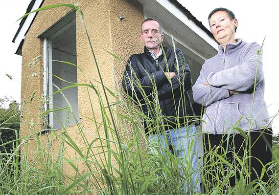 David Creamer and his neighbour Barbara O’Connell next to the uncut grass by their bus stop
