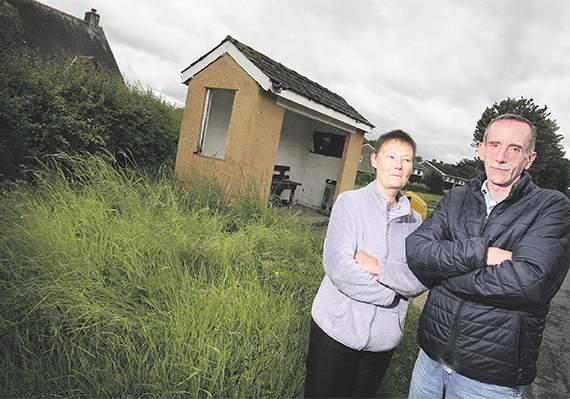 David Creamer and neighbour Barbara O’Connell next to the uncut grass by the bus stop in their cul-de-sac in Groesffordd