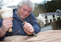 Sculptor chips away at stone rose for memorial garden