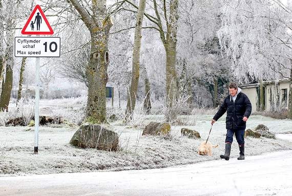 A dog walker out early near a frosty Llangors Lake this morning