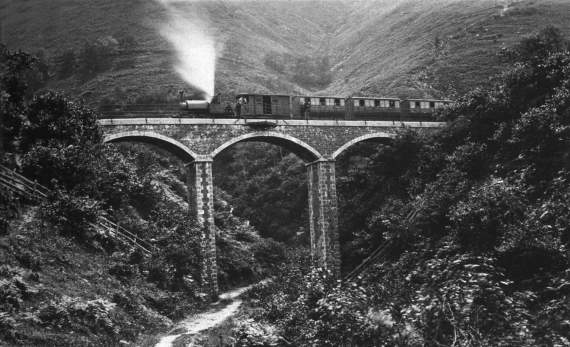 The earliest known photograph of the Talyllyn Railway dating from c.1870 shows Talyllyn with a weatherboard and trailing wheels, but without a cab, on Dolgoch viaduct. The brake van still has an open verandah. It is possible that William Boustead is the fusture sat on Talyllyn’s footplate (Photo supplied by Llyfrgell Genedlaethol Cymru/National Library of Wales)