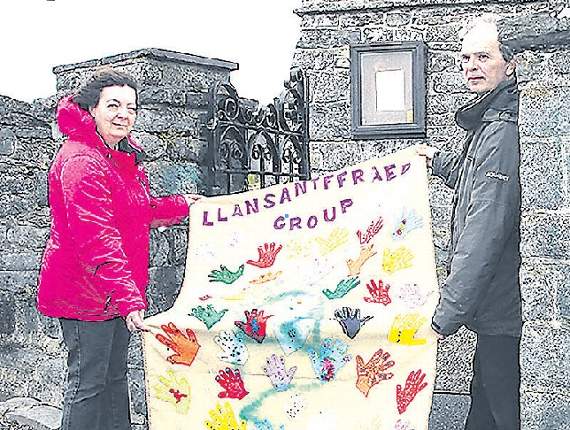 Church warden Wendy Morgan and the vicar of Llanon Rev Julian Smith show the church banner sprayed with green paint