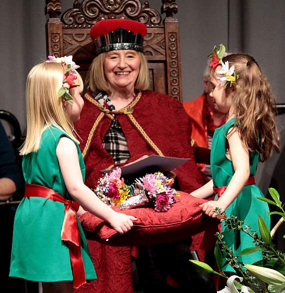 Seren a Sara Fflur, dwy ferch o’r ddawns flodau, yn cyflwyno’r Goron arian fechan i Hannah Roberts