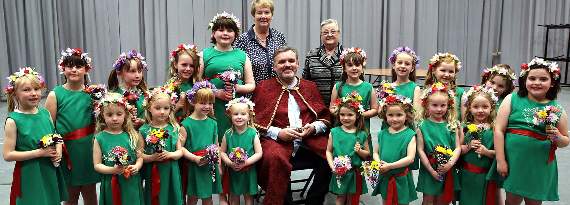 Huw Dylan Owen gyda merched y ddawns flodau, sef disgyblion Ysgol Gynradd Pontrhydfendigaid