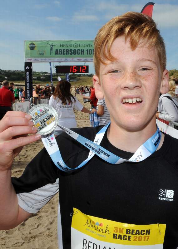 Berian Rhys Hughes looks none the worse pictured with his medal after completing the race in 15.43 minutes, and securing ninth place overall