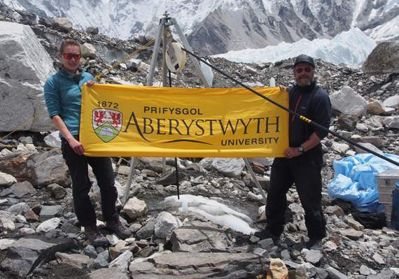 Aberystwyth University’s Katie Miles and Prof Bryn Hubbard fly the Aber flag oat the drill site on the Khumbu glacier. Photo: Bryn Hubbard/Aberystwyth University