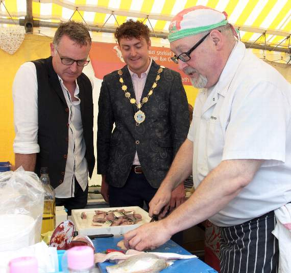 Gareth Jones from Wynnstay, Machynlleth, shows Chris Jones and Aberaeron mayor Rhys Davies the art of fish filleting