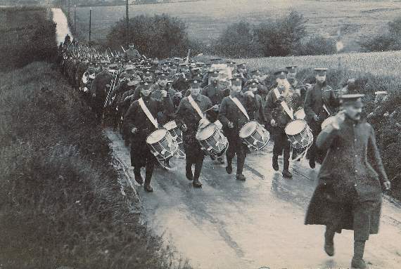 A military band marches through Traws circa 1907