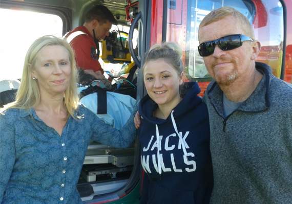 Cara-Capener Jones with her mum Lesley Capener-Jones and uncle Bryan Edwards in front of the Wales Air Ambulance helicopter at Bristol when her father was transported from Bronglais Hospital to Frenchay Hospital for treatment