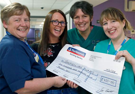 Kizzie Garner is pictured handing over £625 each to Gwenllian Ward staff
