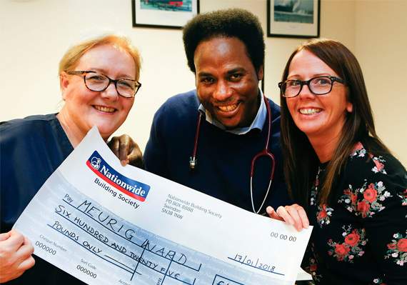 Meurig Ward staff receive a cheque from Kizzie