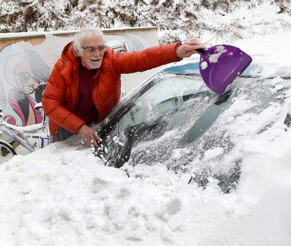 Richard Burnham clearing the snow from his car windscreen at Talybont. 18DPJ08MAR18