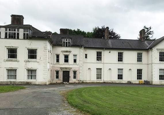 A councillor has accused the university of neglecting Plas Gogerddan mansion and has railed against a decision to plant an orchard on a cricket pitch
