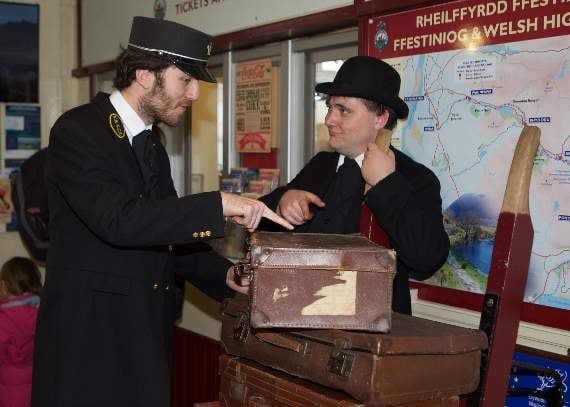 David Smith and Matthew Hall of the Ffestiniog and Welsh Highland Railway loading suitcases in traditional dress