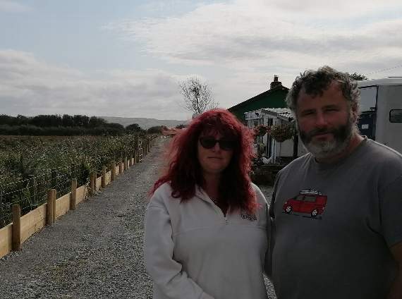 Nia and Wayne Edwards, of Cwtch-Ni Dog Hotel and Greenacre Nursery, have expressed frustration at Natural Resources Wales' attempts to fix a breach in the river