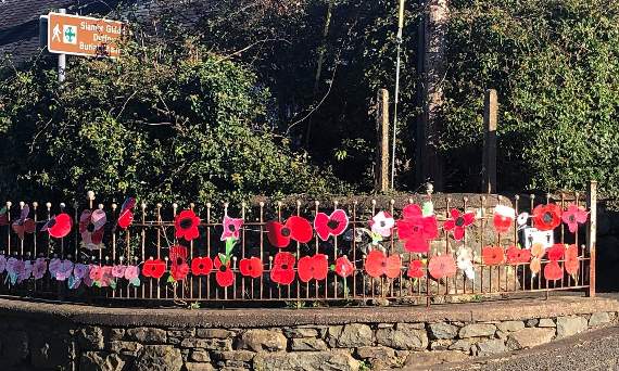 A display of poppies on the railings of Ysgol Dyffryn Ardudwy