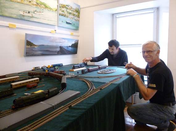 Ben Law and William Howse make an adjustment to the model railway at Stuart House