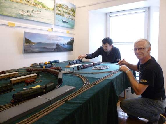 Ben Law and William Howse make an adjustment to the model railway at Stuart House