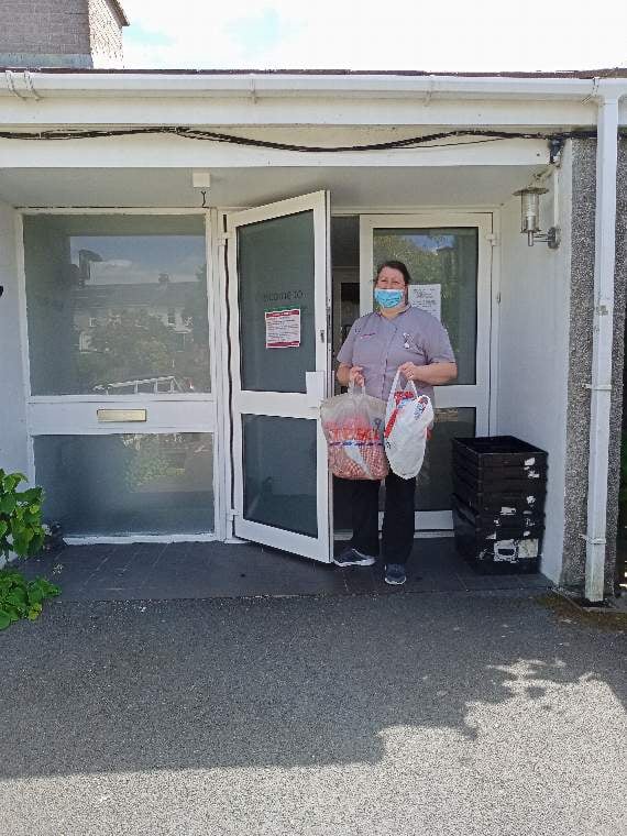 Some of the scrubs being handed to a member of staff at Pengover House in Liskeard