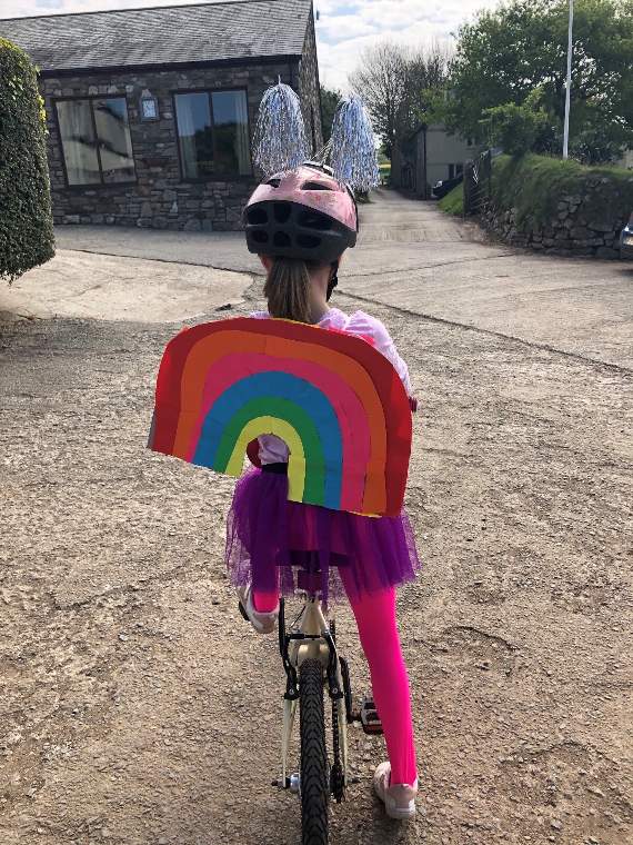 The costume Liliana wore on her last three-mile bike ride reflected the rainbow symbol widely used during the current crisis