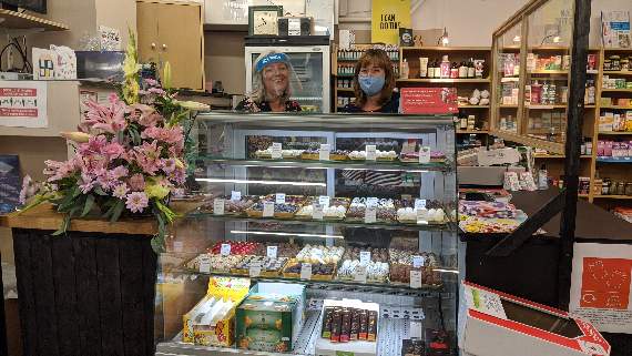 HEALTH and Happiness owner Debbie Vass and staff member Ann Lynch. The cabinet of Belgian chocolates are part of the 'happiness' side of the shop, says Debbie
