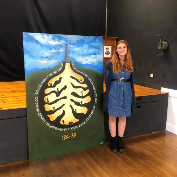 Erin Hilsden with her mural combining Cornish poetry and the mining heritage of Callington and Kelly Bray.