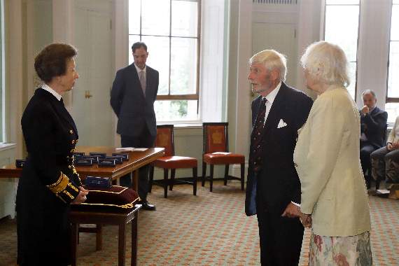 HRH The Princess Royal talks to Captain Colin Brown and his wife Carole before presenting him with his Merchant Navy Medal for Meritorious Service