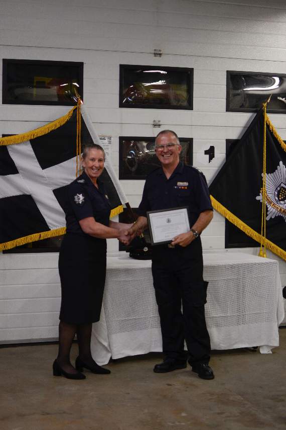 Retiring on-call station manager Danny Smith receives a certificate to mark his 33 years service from Chief Fire Officer Kathryn Billing. Photo: Scarlett Hills-Brooks