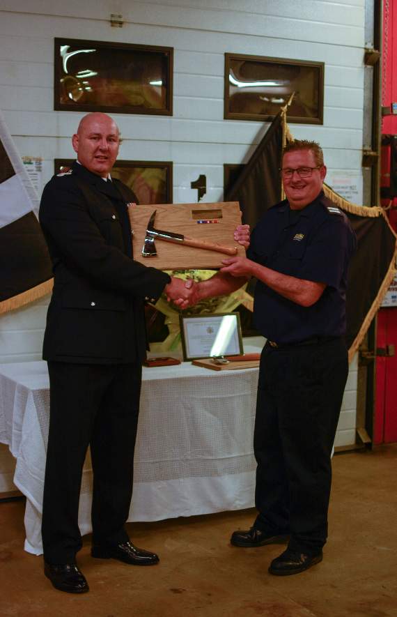 Retiring on-call manager Richard Bailey receives his fire axe from Response Station Manager for East Command Mark Goldsmith. Photo: Scarlett Hills-Brooks