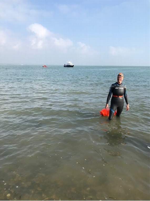Claire coming onto the shore after achieving the Solent swim of around seven kilometres