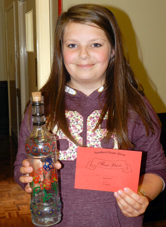 Amy Cheriton (13) awarded a first prize for her decorated bottle at Sandford Flower Show.