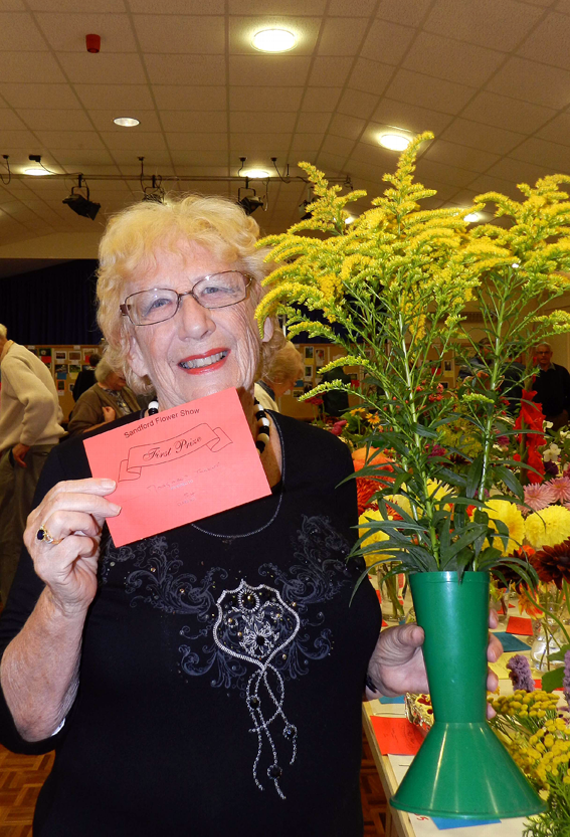 “Courier” correspondent Margaret Tucker with a vase of Golden Rod flowers that won her a first prize.