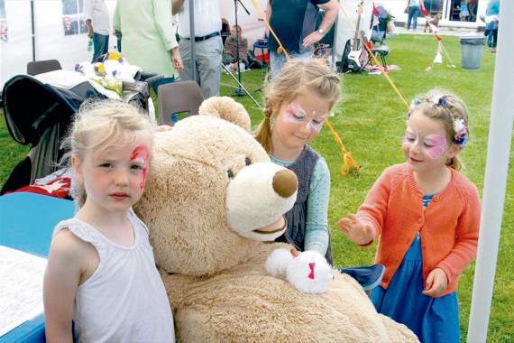 Showing off their painted faces were these young ladies with the huge teddy bear to be won if someone guessed its proper name. It was being introduced to a much smaller, white friend. SR 6273