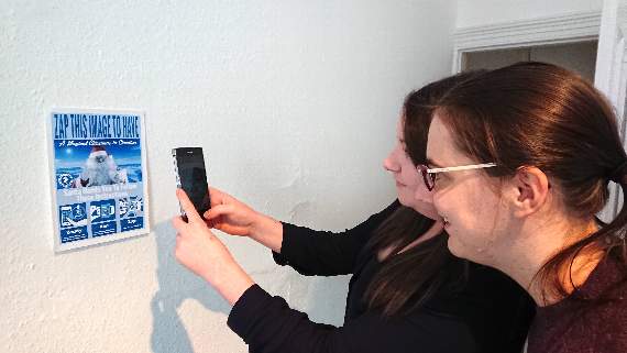 Demonstrating how to use the augmented reality app to view one of the many magical experiences on a smartphone or tablet.