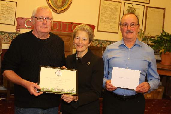 Pete Beal, from Keep Crediton Clean, left, receiving an It’s Your Neighbourhood Britain In Bloom South West competition award from Lynette Talbot, RHS Judge and Chair of Sidmouth In Bloom, pictured with Cllr Michael Szabo, Chairman of the Floral Crediton committee, right. AQ 5217
