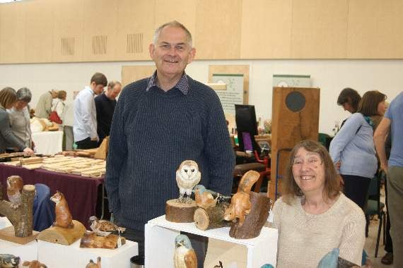 Colin Burlton from Bow with his wife Maureen and a few of his animal and bird carvings at Rosemoor. SR 8412