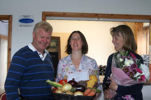 Centre Sue Lewis holding her basket of vegetables that took first prize with the judges Dave and Sarah Fox. SR 9959