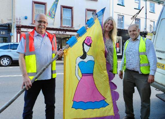 John Smith (Tesco Community Champion), Charlotte Turner (local artist) and Richard Adams helping to put up flags to mark the start of CredFest. NP 310519 09