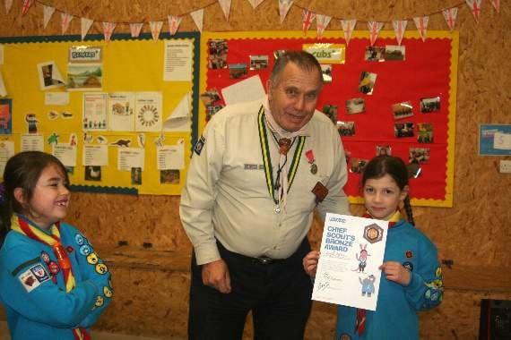 Emily Jeffery shows off the Bronze Award certificate and badge she received from George Davey. SR 2929