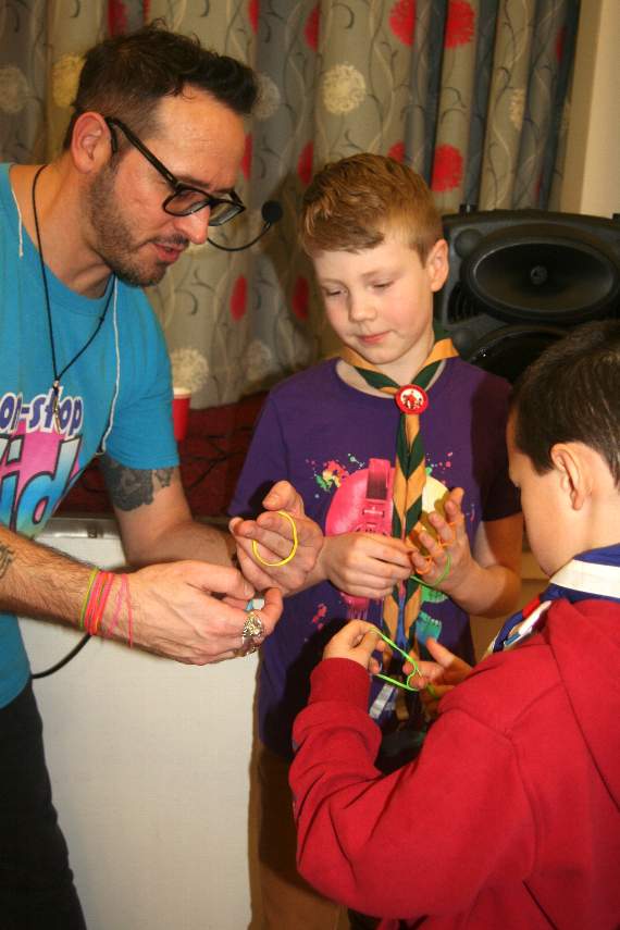 Magician TJ demonstrating an elastic band trick. SR 2875