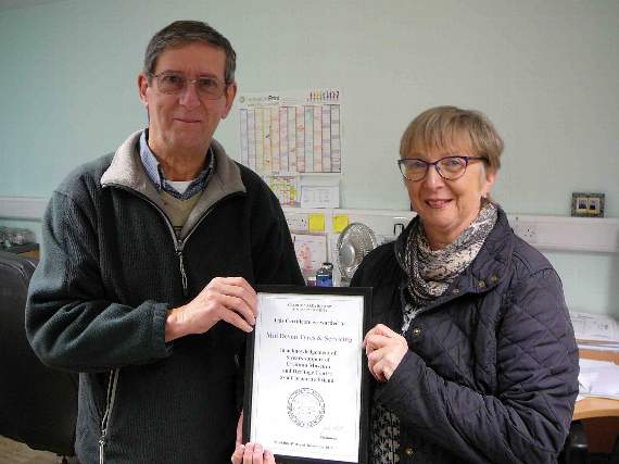 John Heal presented Lynda Iles with an award at Mid Devon Tyres.