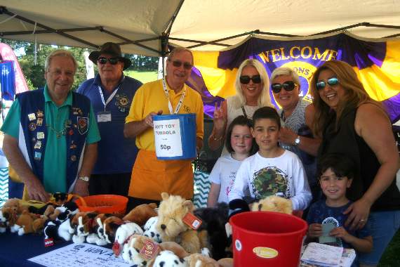 Members of the Lions Club of Crediton and District with customers on their soft toy tombola stand. SR 2293