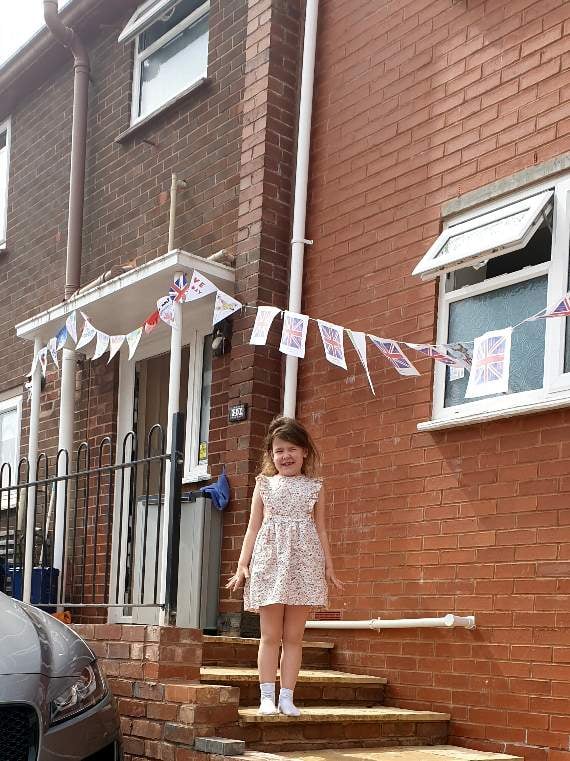 Martha McDonald on her doorstep with the bunting she helped to make.