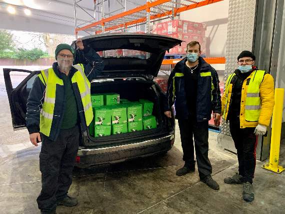 Crediton Dairy staff with one of two cars loaded with cartons of long-life milk going into food parcels.