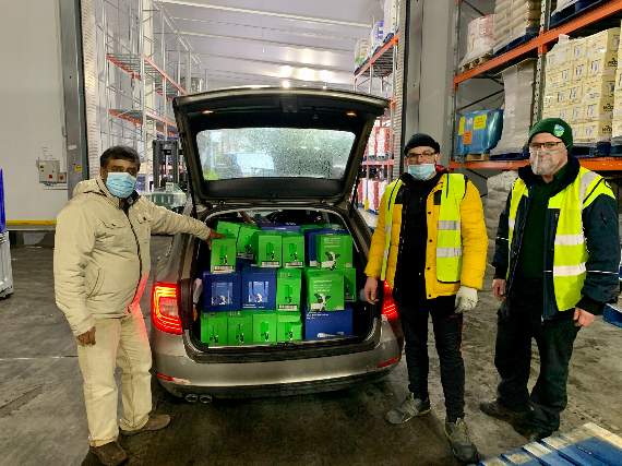Shahar Lashkor, left, of Inclusive Exeter and Crediton Dairy representatives with milk for the food parcels.