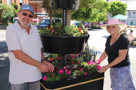 Bert and Margaret Jewell beside one of the flower tubs they care for in Crediton Town Square. AQ 1423
