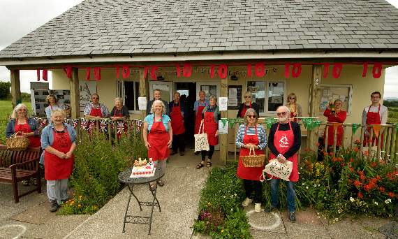 Spreyton shop decorated with bunting for its 10 years, a small band of volunteers outside with shop manager Bella Snook.