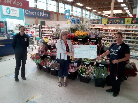 Chris Parsons, centre from Crediton Foodbank, receiving the Tesco cheque.