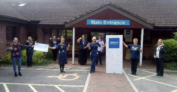 The cheque and ‘Thank You’ board being presented at Crediton Hospital.