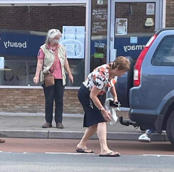 Wendy Archer from the Red Cross shop tries to rescue the baby bunny hiding under a car on Crediton High Street.